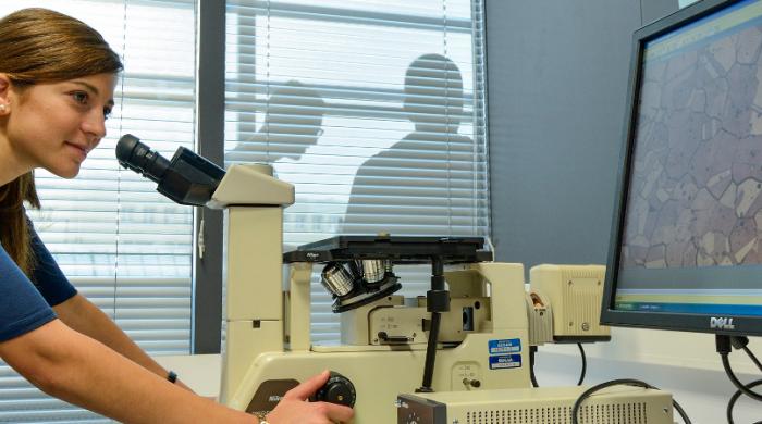Visuel présentation une étudiante utilisant un microscope